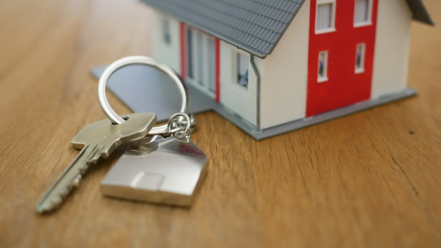 white and red wooden house miniature on brown table