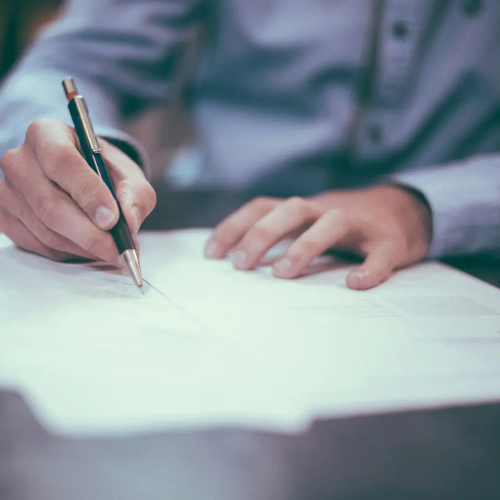 man writing on paper